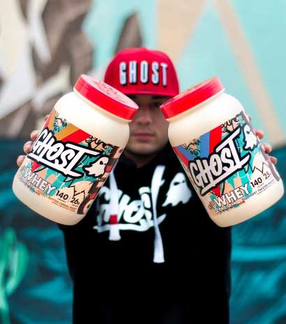 man holding up 2 tubs of ghost lifestyle whey protein on an angle